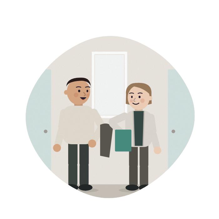 A son talks calmly with a ward worker in a corridor, his coat over his arm.