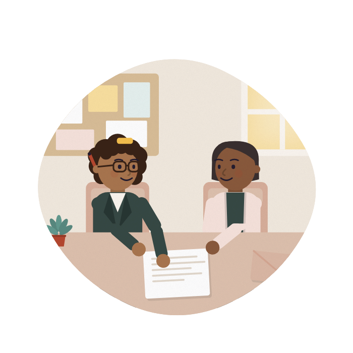 An adviser and a carer talk across a desk at a community centre, both looking at the same letter.