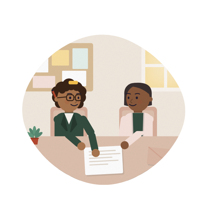 An adviser and a carer talk across a desk at a community centre, both looking at the same letter.