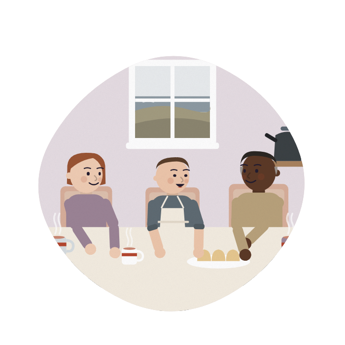 Two siblings sit at their kitchen table with a visitor, a plate of scones between them.