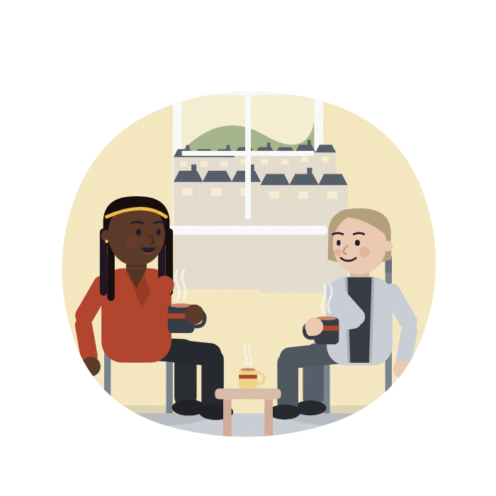 A woman talks and an assessor listens, both with cups of tea.