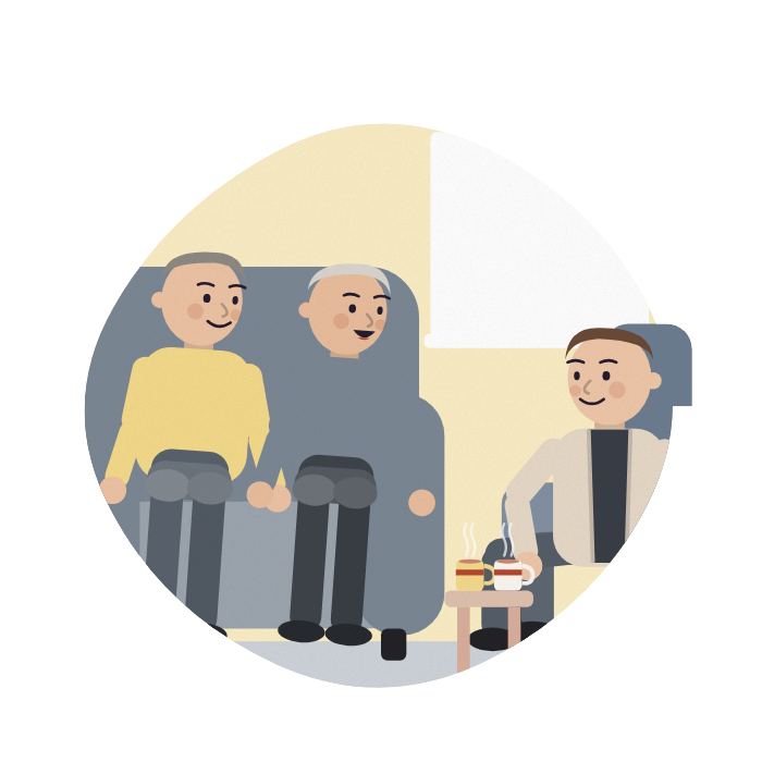A man and his husband sit with an assessor in their front room.