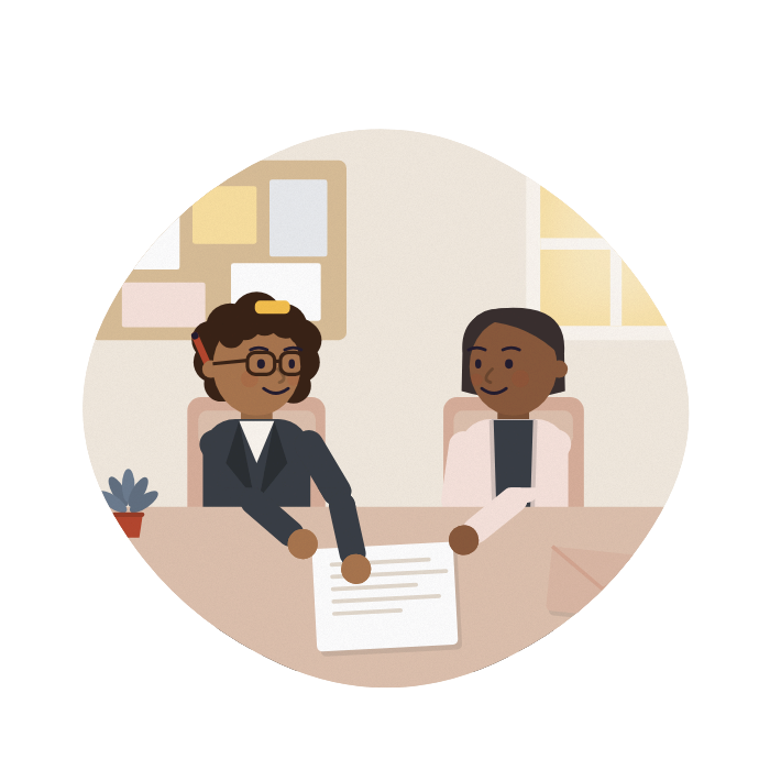 An adviser and a carer talk across a desk at a community centre, both looking at the same letter.