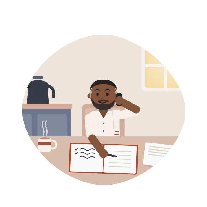 A man makes a phone call at his kitchen table, writing notes in a notebook beside a letter.