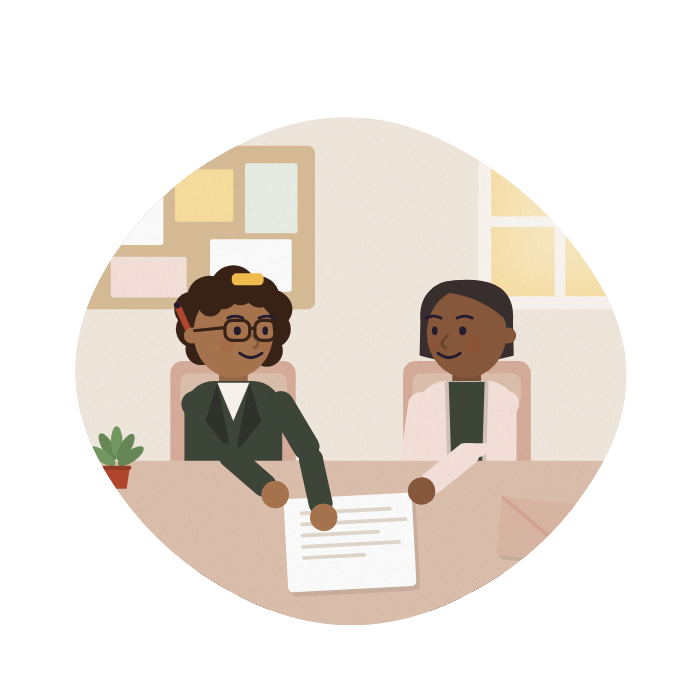 An adviser and a carer talk across a desk at a community centre, both looking at the same letter.