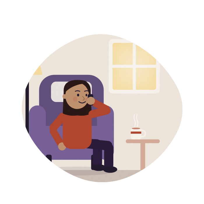A woman in an armchair talks on the phone, a cup of tea beside her.