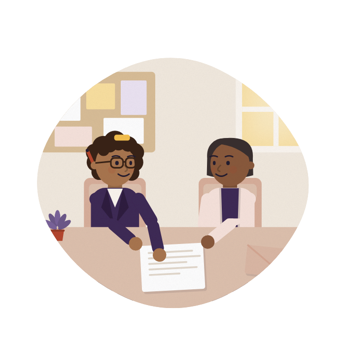 An adviser and a carer talk across a desk at a community centre, both looking at the same letter.