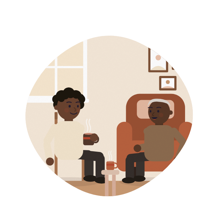 An older man talks with his daughter in his armchair, both smiling.